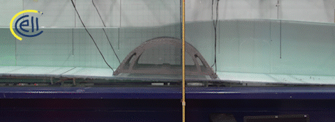 Animation of a wave passing over a model arc reef in a wave flume, with the computed flow speeds overlaid on the video